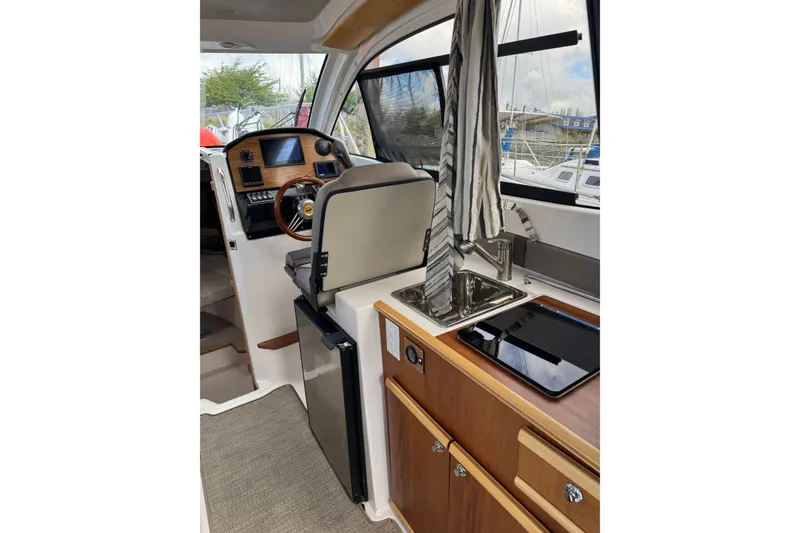 Slide: The Image of Interior of 2022 Cutwater boat with helm, sink, and wooden cabinetry. - 8