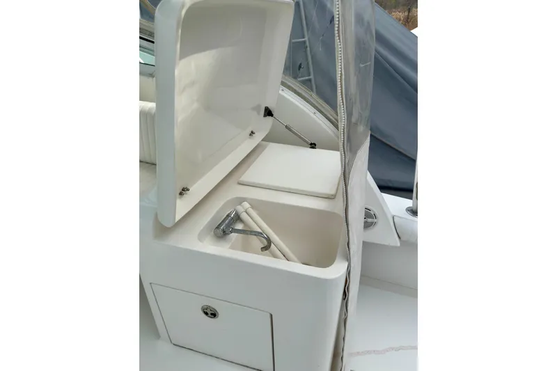 Slide: The Image of Open storage compartment on 2004 Topaz 32 Express boat with faucet and cover. - 17