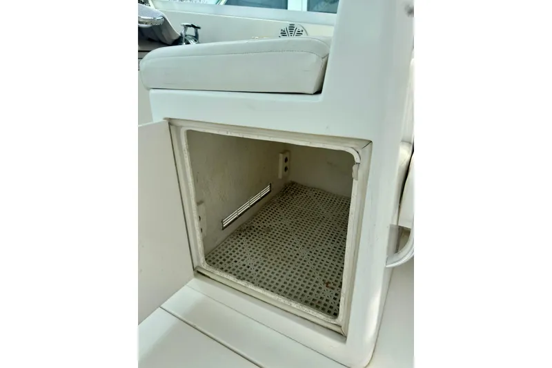 Slide: The Image of Storage compartment on a 2004 Topaz 32 Express boat, featuring a white cushioned seat. - 19