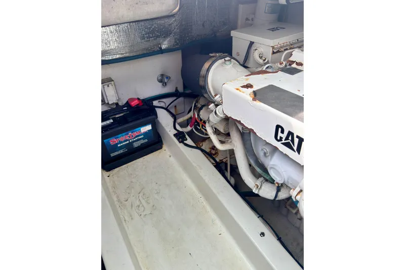 Slide: The Image of Engine compartment of 2004 Topaz 32 Express boat with visible battery and CAT engine. - 22