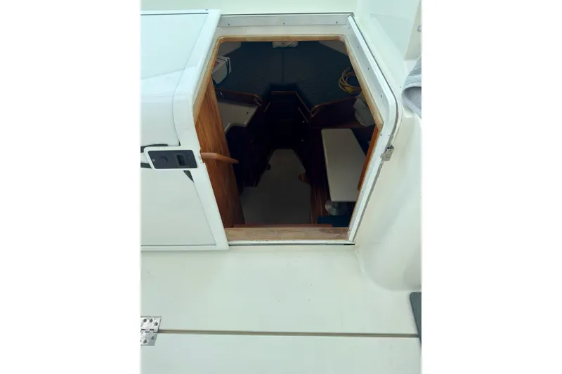 Slide: The Image of Entrance to cabin of 2004 Topaz 32 Express boat, showing interior seating and wooden accents. - 25
