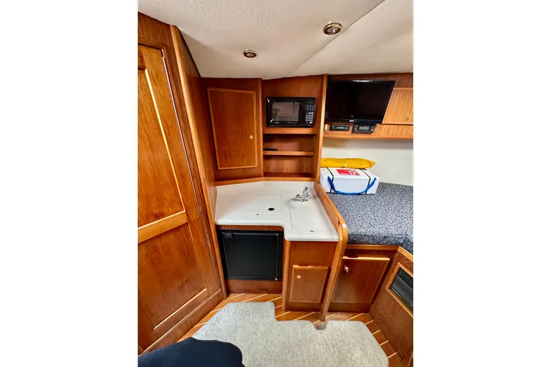 Slide: The Image of Interior of 2004 Topaz 32 Express boat with kitchenette and cozy sleeping area. - 26