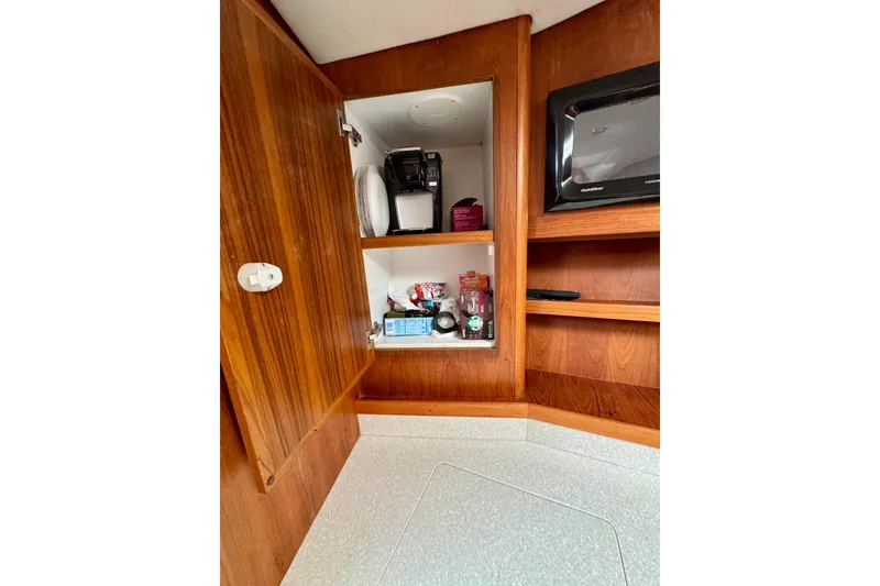Slide: The Image of 2004 Topaz 32 Express interior with wooden cabinetry, microwave, and storage shelves. - 29