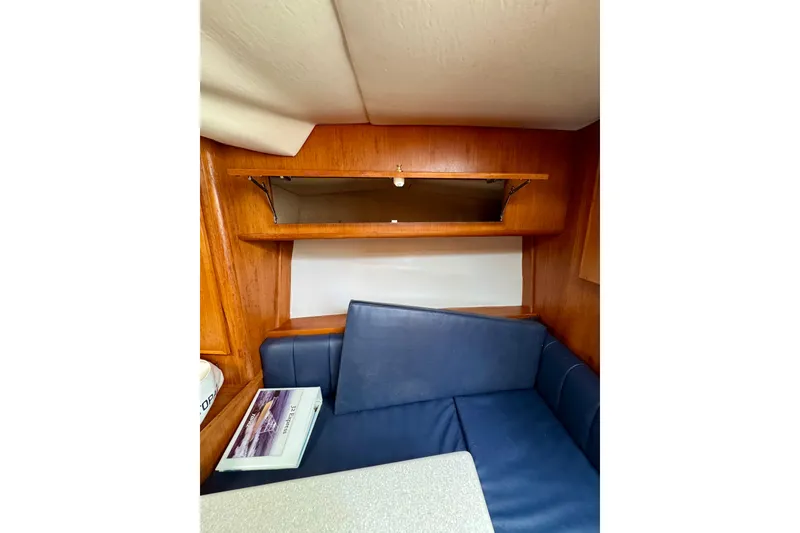 Slide: The Image of Interior of 2004 Topaz 32 Express boat with blue seating and wooden shelving. - 33