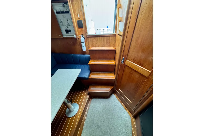 Slide: The Image of Interior of 2004 Topaz 32 Express boat with wooden stairs and seating area. - 34