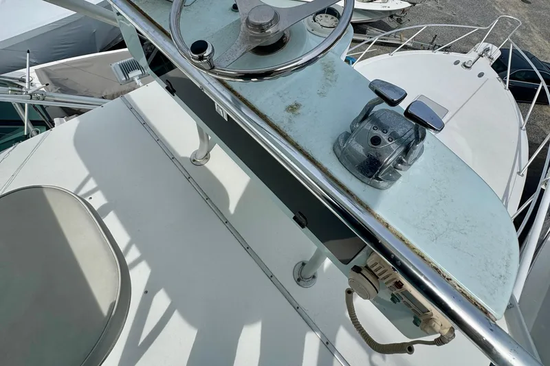 Slide: The Image of 2004 Topaz 32 Express boat helm with steering wheel and throttle controls. - 7