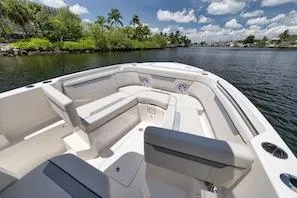 Slide: The Image of 2027 Sailfish 252 CC boat with spacious seating on a sunny day by the water. - 11