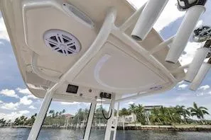 Slide: The Image of 2027 Sailfish 252 CC boat interior with speaker and rod holders, under a clear sky. - 16