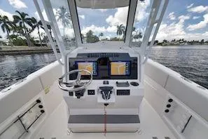 Slide: The Image of 2027 Sailfish 252 CC boat cockpit with dual screens, steering wheel, and waterfront view. - 5