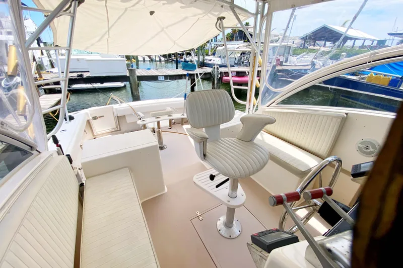 Slide: The Image of 1997 Albemarle 30 Express boat interior with helm, seating, and marina view. - 12