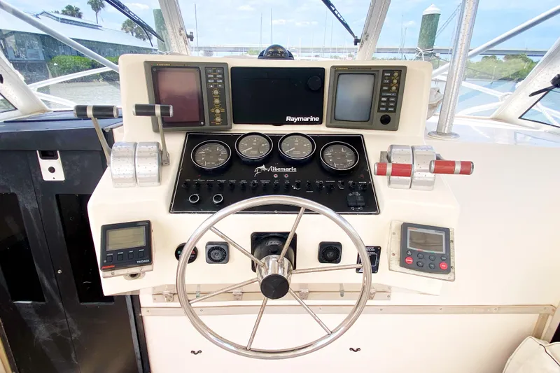 Slide: The Image of Control panel of a 1997 Albemarle 30 Express boat with steering wheel and gauges. - 14