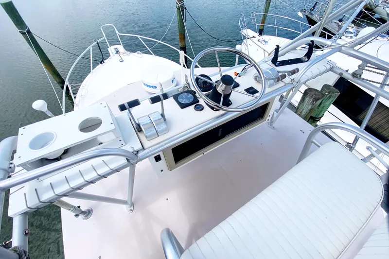 Slide: The Image of 1997 Albemarle 30 Express boat helm with steering wheel and controls, docked on calm water. - 18