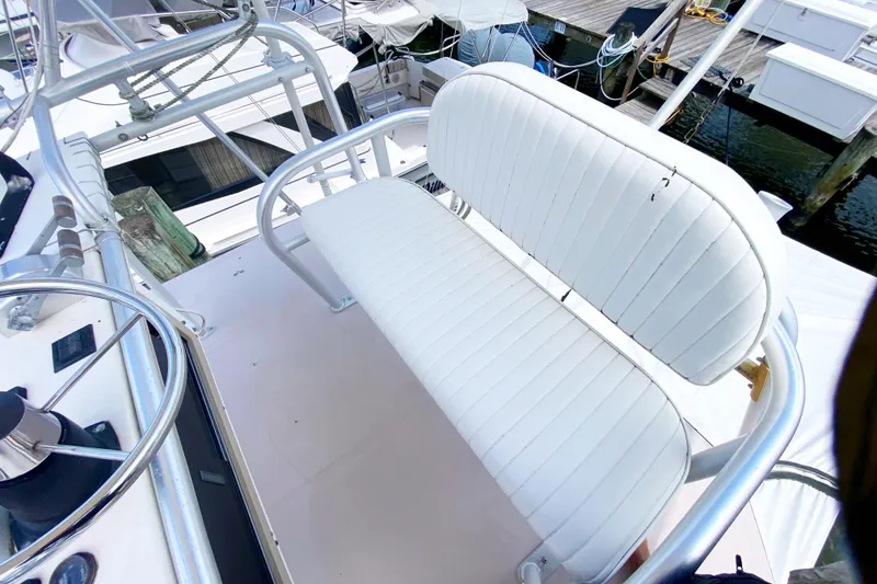 Slide: The Image of 1997 Albemarle 30 Express boat with white cushioned seating and steering wheel, docked at marina. - 20