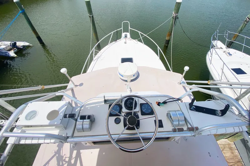 Slide: The Image of 1997 Albemarle 30 Express boat helm with steering wheel and gauges, docked in marina. - 21