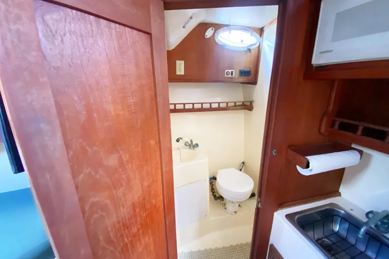 Slide: The Image of Interior of 1997 Albemarle 30 Express boat bathroom with sink and toilet. - 31