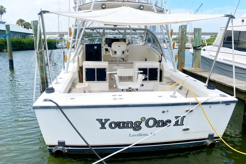 Slide: The Image of 1997 Albemarle 30 Express boat docked, rear view with canopy and seating area. - 5
