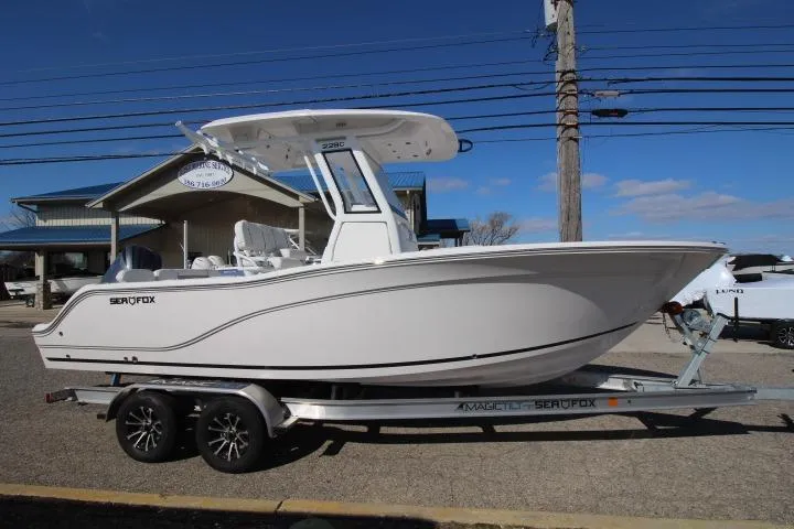 The Image of 2026 Sea Fox 228 Commander boat on trailer, parked outdoors under clear sky. - 0