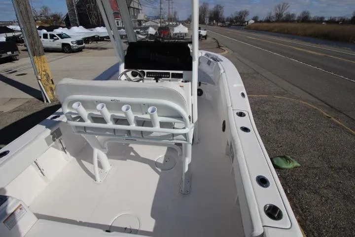 Slide: The Image of 2026 Sea Fox 228 Commander boat interior with seating and rod holders, parked near a road. - 17