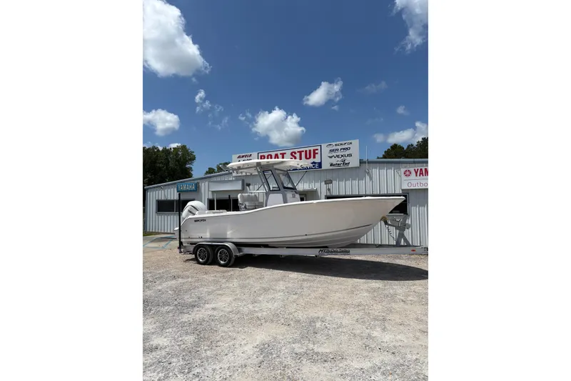 The Image of 2026 Sea Fox 248 Commander boat on trailer at dealership, sunny day. - 1