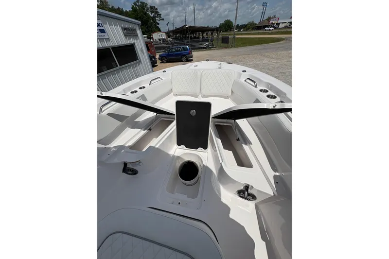 Slide: The Image of 2026 Sea Fox 248 Commander boat, white interior, parked near a building and cars. - 9