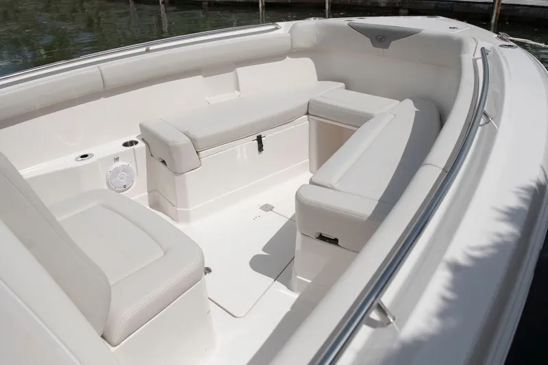 Slide: The Image of 2027 Sailfish 272 CC boat interior with white cushioned seating and cup holders. - 11