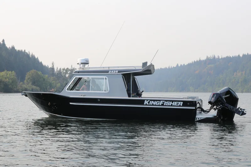 The Image of 2026 KingFisher 2425 Escape HT boat on a serene lake with forested background. - 0
