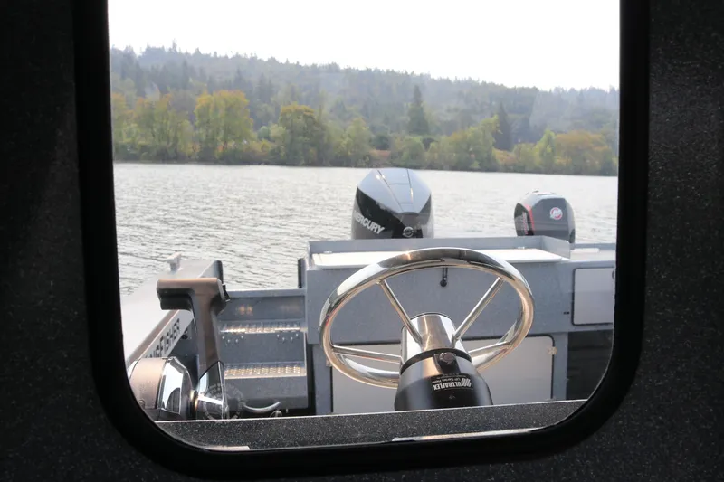 Slide: The Image of Interior view of 2026 KingFisher 2425 Escape HT boat steering wheel on a lake. - 19