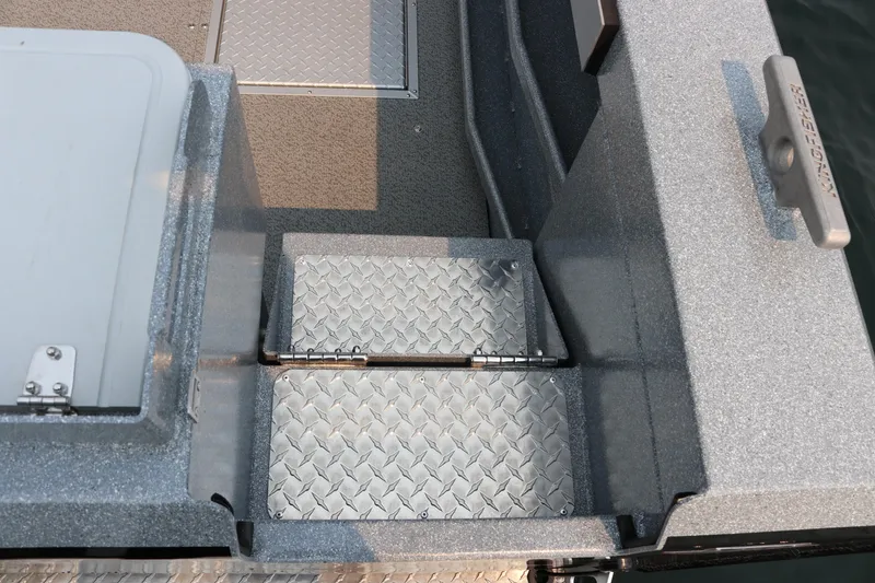 Slide: The Image of KingFisher 2425 Escape HT 2026 boat deck with diamond plate flooring and storage hatch. - 31