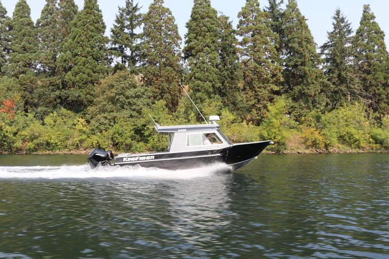 Slide: The Image of 2026 KingFisher 2425 Escape HT boat cruising on a scenic lake with forest backdrop. - 39