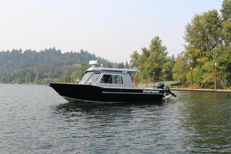 Slide: The Image of 2026 KingFisher 2425 Escape HT boat cruising on a scenic lake. - 40