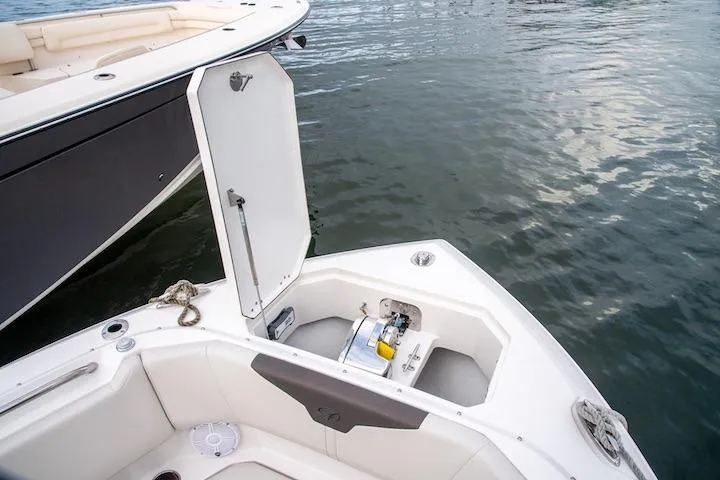 Slide: The Image of 2027 Sailfish 276 DC boat with open storage compartment on calm water. - 13