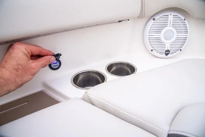 Slide: The Image of Hand adjusting USB port on 2027 Sailfish 276 DC boat with cup holders and speaker. - 14