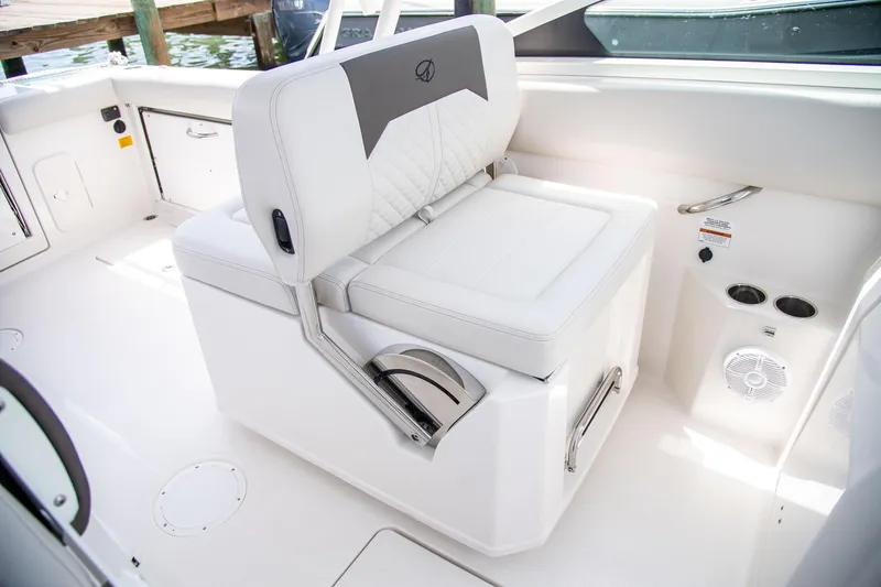 Slide: The Image of 2027 Sailfish 276 DC boat interior with white cushioned seating and cup holders. - 17