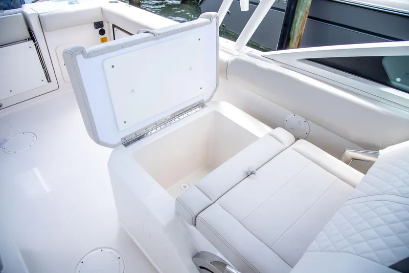 Slide: The Image of 2027 Sailfish 276 DC boat interior with open storage compartment and cushioned seating. - 27