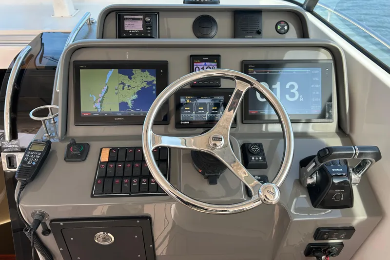 Slide: The Image of Control panel of 2018 Pursuit OS 385 Offshore boat with navigation screens and steering wheel. - 11