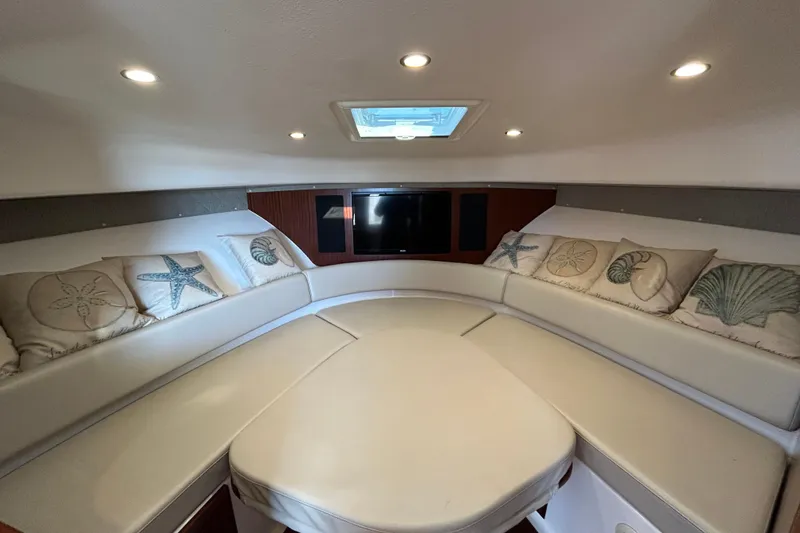 Slide: The Image of 2018 Pursuit OS 385 Offshore cabin with plush seating and decorative pillows. - 15