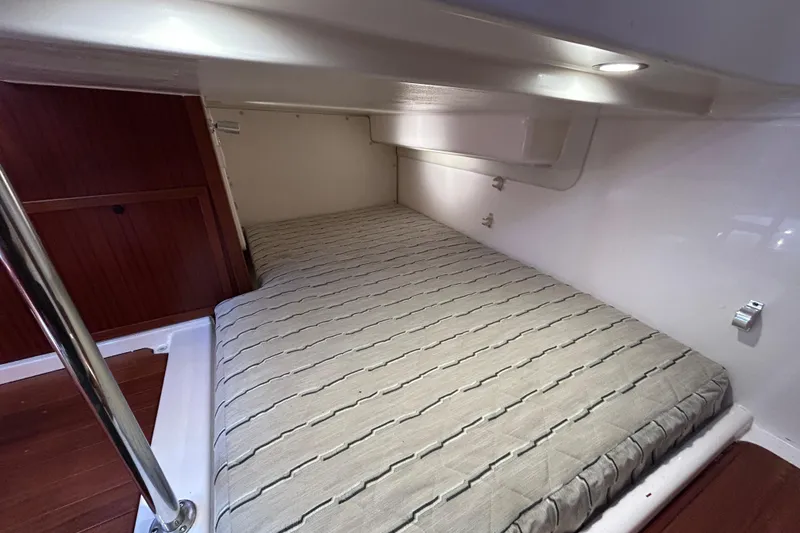 Slide: The Image of 2018 Pursuit OS 385 Offshore cabin interior with cozy bed and wooden accents. - 18