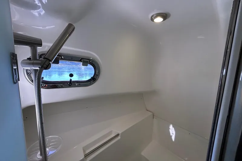 Slide: The Image of 2018 Pursuit OS 385 Offshore boat bathroom with shower and porthole window. - 22