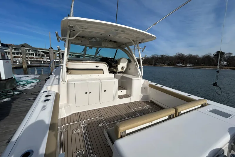 Slide: The Image of 2018 Pursuit OS 385 Offshore boat docked, showcasing spacious deck and seating area. - 4
