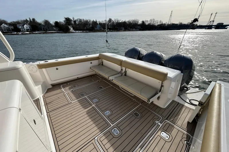 Slide: The Image of 2018 Pursuit OS 385 Offshore boat deck with seating, overlooking calm waters. - 5