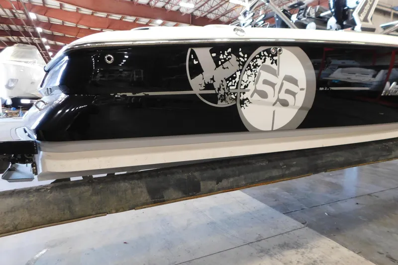 Slide: The Image of 2009 MasterCraft X55 boat in storage, featuring sleek black and white design. - 10