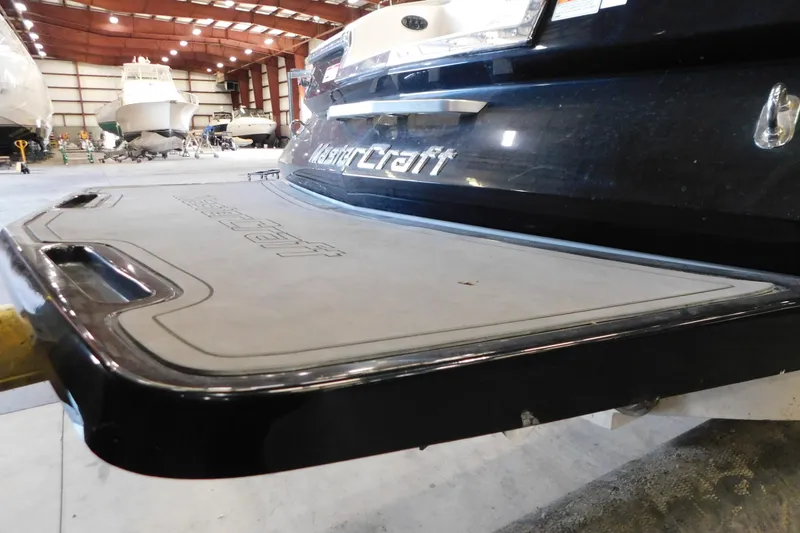 Slide: The Image of 2009 MasterCraft X55 boat in a storage facility, showcasing rear platform. - 12