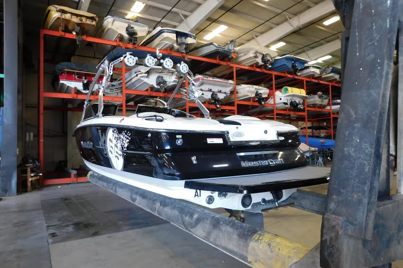 Slide: The Image of 2009 MasterCraft X55 boat in storage facility, elevated on a lift. - 13