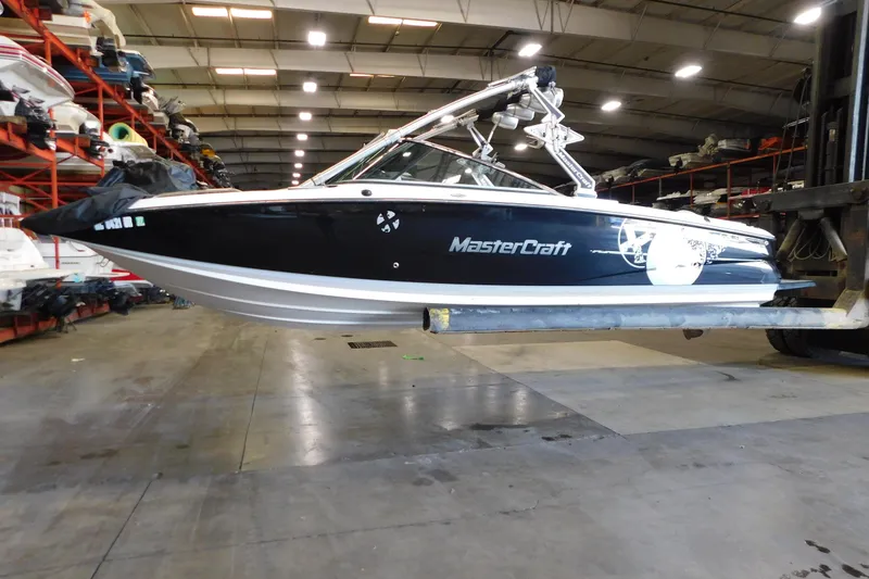 Slide: The Image of 2009 MasterCraft X55 boat in warehouse, elevated on forklift for storage. - 15