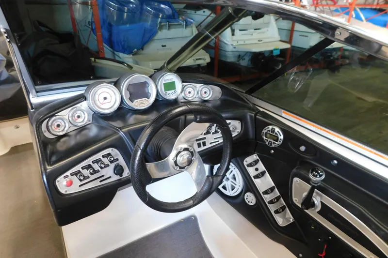 Slide: The Image of 2009 MasterCraft X55 boat dashboard with steering wheel and control gauges. - 23