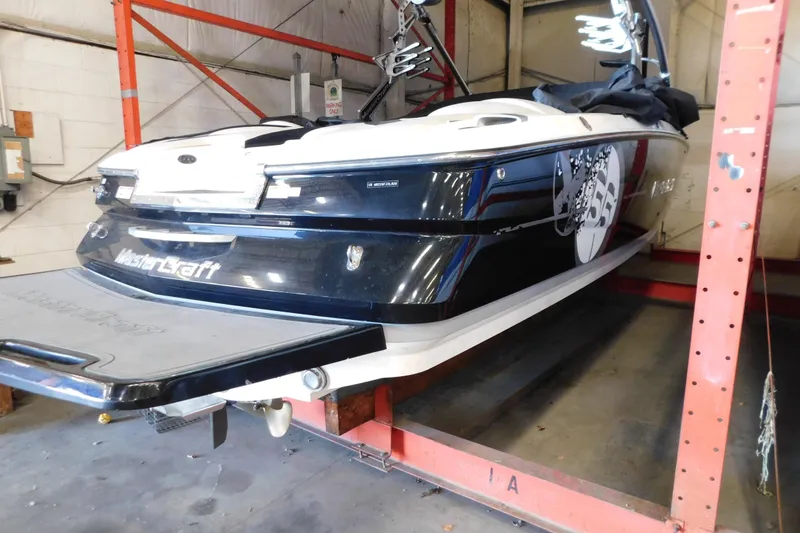 Slide: The Image of 2009 MasterCraft X55 boat in storage, showcasing sleek design and branding. - 3