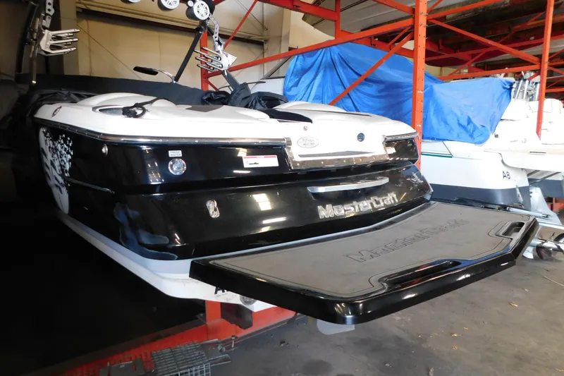 Slide: The Image of 2009 MasterCraft X55 boat in storage, featuring sleek black and white design. - 6