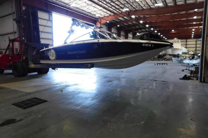 Slide: The Image of 2009 MasterCraft X55 boat lifted in a spacious indoor facility. - 8