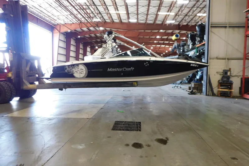 Slide: The Image of 2009 MasterCraft X55 boat lifted in a spacious warehouse. - 9