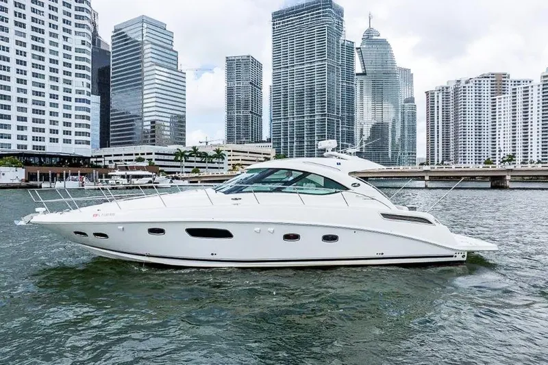 The Image of 2009 Sea Ray 43 Sundancer yacht cruising in urban waterfront setting. - 1